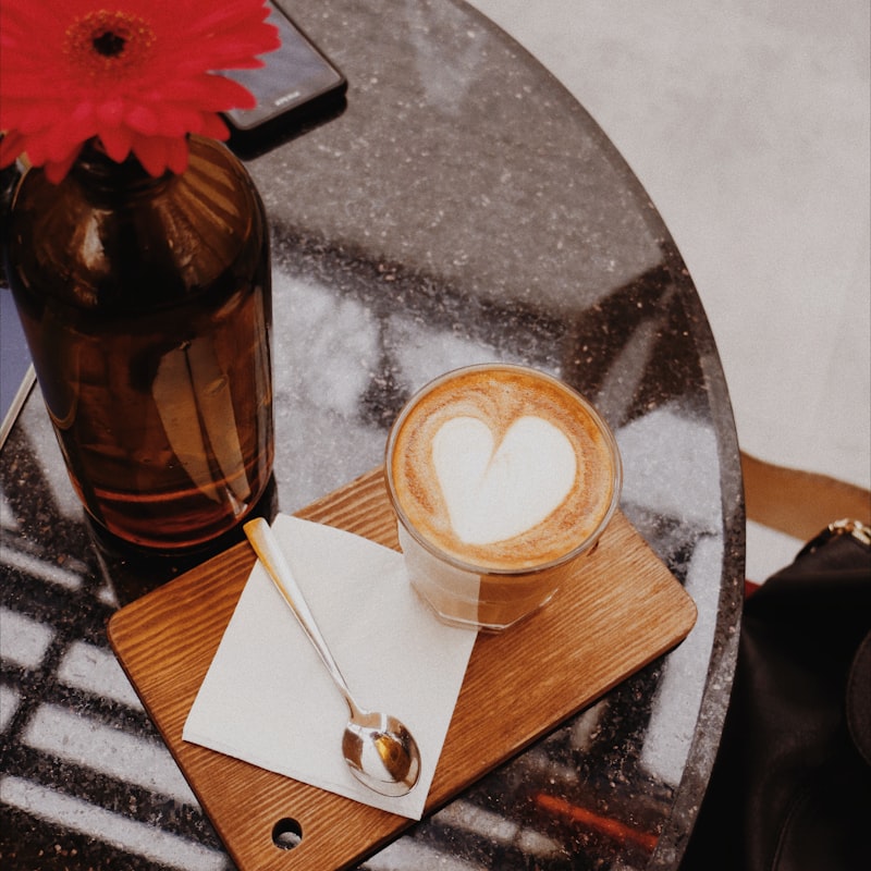 Virágcsokor és szív latte art egy kávézó asztalán